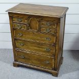 A reproduction oak chest of drawers of small size, with a small frieze cupboard, width 33", height