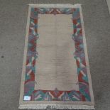 An Indian Nepal cream ground wool rug, with coloured border, 160cm x 92cm