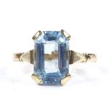 An unmarked gold emerald-cut aquamarine dress ring, with openwork bridge, settings test as 22ct