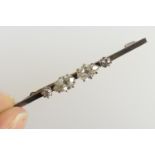 Diamond bar brooch, having two pear cut diamonds of approx. 0.5ct each, flanked by two smaller