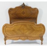 French carved walnut double bed, circa 1910, the headboard carved with a central shell and floral