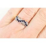 Sapphire and diamond fancy cluster ring, set with ten small round cut sapphires in a wavy pattern