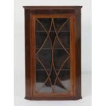 Mahogany and inlaid glazed hanging corner cupboard, the astragal glazed door opening to three