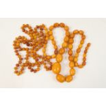 Two butterscotch amber necklaces, one having graduated oval beads, the largest approx. 28mm, with