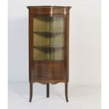 Edwardian mahogany and inlaid free standing corner display cabinet, serpentine front with dentil