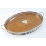 George V oak and silver plated oval serving tray, with galleried edge and shield shaped cartouche