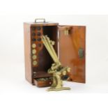 Brass binocular microscope, by S & B Solomons, 39 Albermarle Street, London, with two eyepieces,