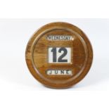 George V oak circular wall calendar, with revolving printed cloth day and date, 31cm diameter