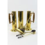 Pair of Arts and Crafts style brass cylinder poker stands, with flared trumpet base, wooden