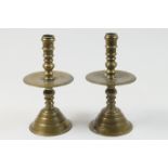 Pair of Dutch bell metal candlesticks, 18th Century, multi-knopped stems with wide drip pan, over