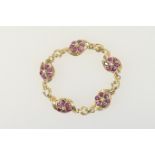 Ruby and diamond flowerhead cluster bracelet in 14ct gold, having five flowerheads centred with a