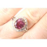 Pink spinel and diamond cluster ring, the oval spinal of approx. 2.5cts (9.5mm x 7.8mm), in a