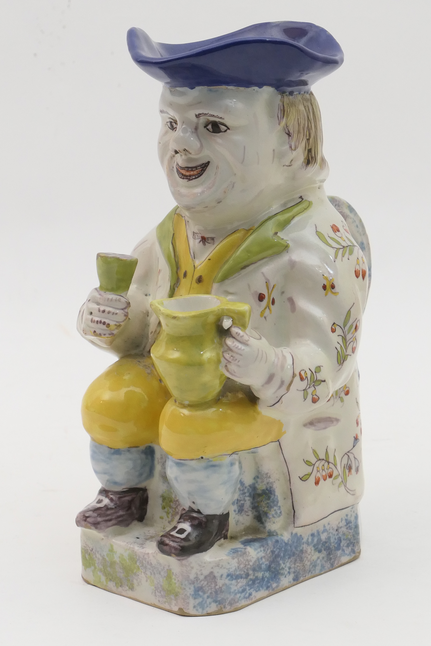 French faience toby jug, in the style of Quimper, traditionally modelled and decorated with yellow