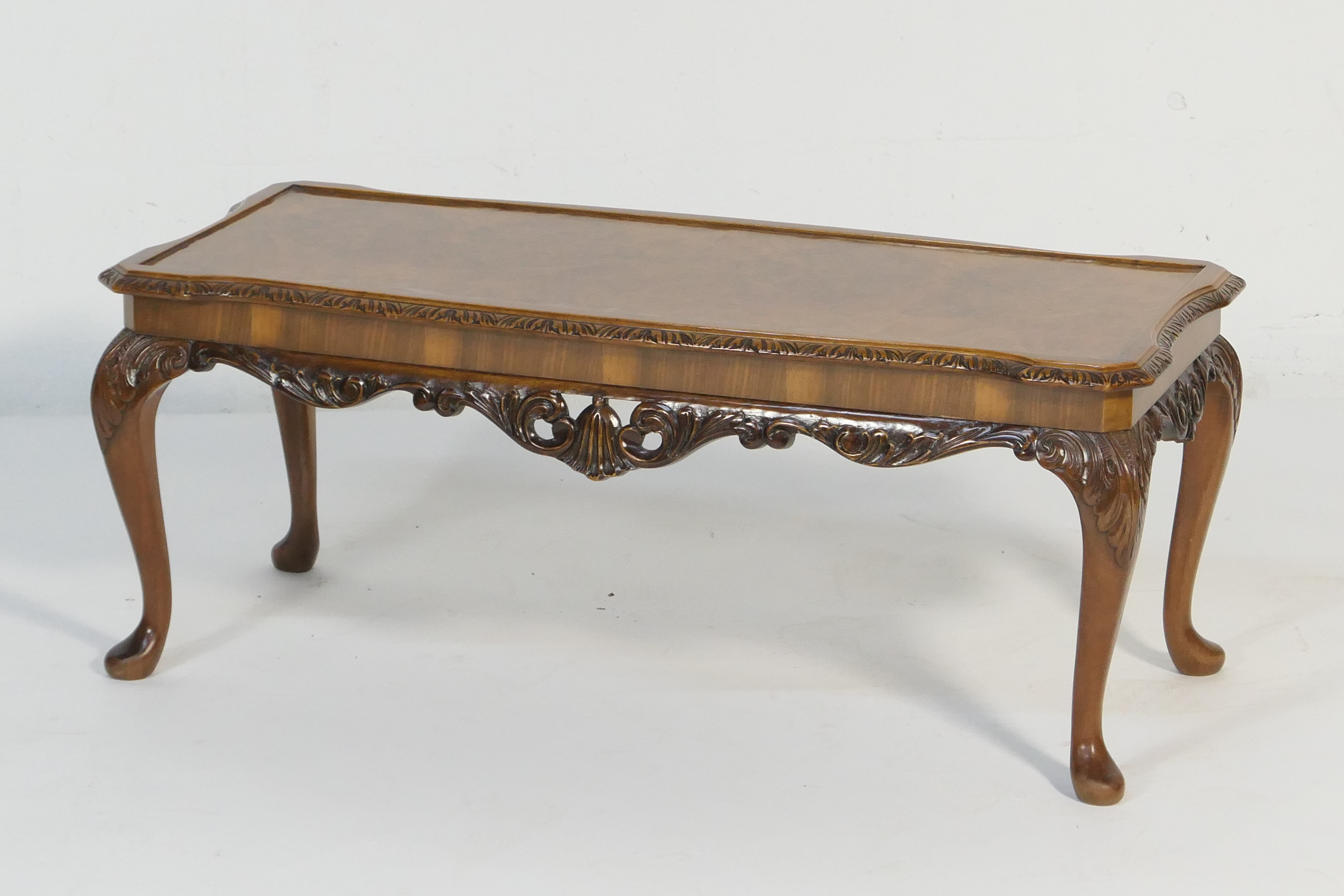 Burr walnut carved coffee table, shaped rectangular form raised on acanthus carved cabriole legs