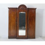 Victorian mahogany breakfront wardrobe, circa 1870, having a carved and arched ogee moulded
