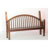 Unusual Lutyens style mahogany settle, with an arched stick back with chamfered square section