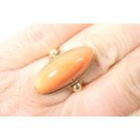 9ct gold and cabochon coral dress ring, the coral of approx. 22mm x 9mm, on a split shank ring