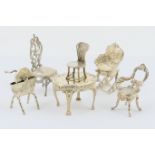 Six white metal miniatures comprising two sterling silver chairs with import marks for London 1897