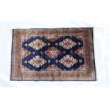 Persian woollen rug, mid 20th Century, dark blue field with lozenge shaped reserves in fawn and