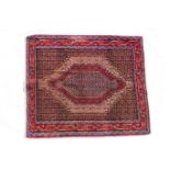 Persian woollen square rug, having a blue pole lozenge and stepped lozenges in pink and fawn,