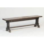 Old oak bench, 19th Century, single plank seat raised on chamfered splat supports united by a foot