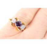 Amethyst and diamond three stone ring, the central round cut amethyst flanked by two small round