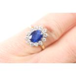 Sapphire and diamond cluster ring, the central oval sapphire measuring approx. 8mm x 6mm, surrounded