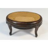 Early Victorian rosewood footstool, the oval caned top raised on short cabriole legs, 38cm x 28cm