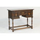 Jacobean Revival oak hall table, circa 1910, fitted with three moulded panel drawers with brass tear