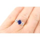 Sapphire and diamond three stone ring, the central oval cut sapphire of approx. 0.70ct, flanked by