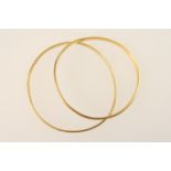 Two gold bangles, probably 18ct, both of plain circular form, internal diameter approx. 6-6.8cm, the