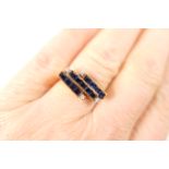 Sapphire and diamond cluster ring, modernist style set with 13 small square cut sapphires, channel
