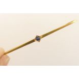 18ct gold and sapphire bar brooch, single small round cut sapphire set on a blade bar, marked '750',