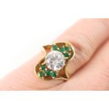 Emerald and cubic zirconia cluster ring, the central brilliant cut white stone bordered with small