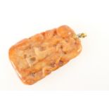 Chinese carved red jadeite pendant, worked with a lady walking in a garden, the reverse being a