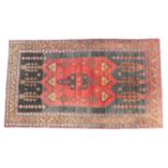 Hamadan woollen rug, red field on an abrashed black ground with brown leaf border, size approx.