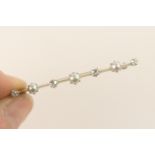 Diamond and pearl bar brooch, set with four small round brilliant cut diamonds, dispersed with three