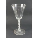 Large wine glass, with a deep plain bowl over a multi strand and double helix stem and folded