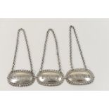 Three Victorian silver decanter labels, each of oval form with gadrooned edge, pierced with '