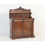 Victorian mahogany chiffonier, circa 1860, having a carved panel back with a shelf over a base