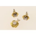Suite of diamond solitaire jewels, comprising pair of earrings and a pendant, each of flowerhead