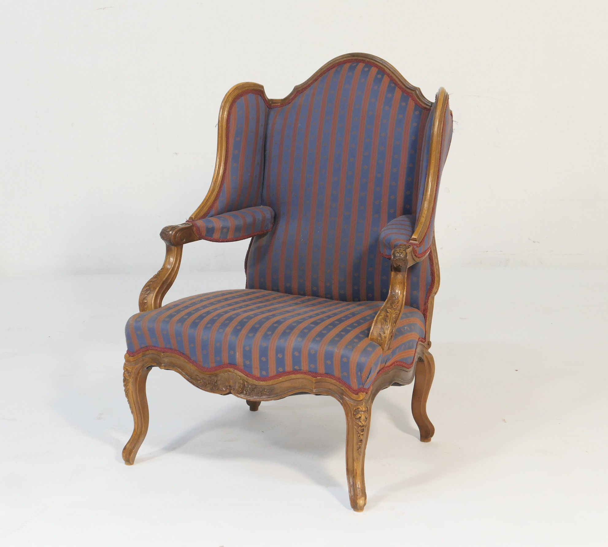 French walnut and upholstered wing armchair, late 19th Century, upholstered throughout in blue and