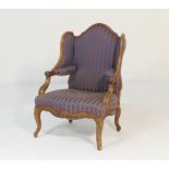 French walnut and upholstered wing armchair, late 19th Century, upholstered throughout in blue and