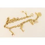 18ct gold chain link charm bracelet, having alternate smooth and textured links and eight charms,