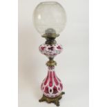 Bohemian ruby and white overlay glass and brass pedestal oil lamp, having an etched spherical