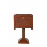A flat-fronted top cabinet on a single foot, Lusíada, carved teak decorated with foliate scrolls,