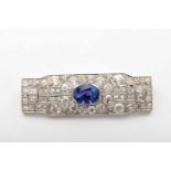 A Brooch, Art Deco, 750/1000 gold and 950/1000 platinum, set with an oval cut Ceylon sapphire with