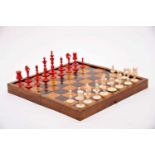 A CALVERT Chess Pieces and Board/Box, carved ivory with one of the sets dyed red, walnut board