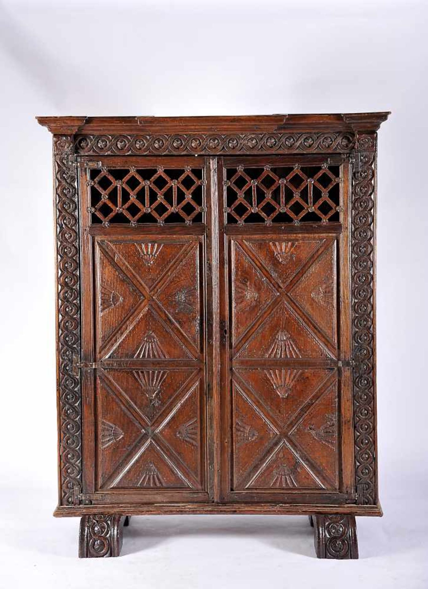 A Two-door Glassware Cupboard, chestnut, carved padded doors and friezes, pierced doors upper