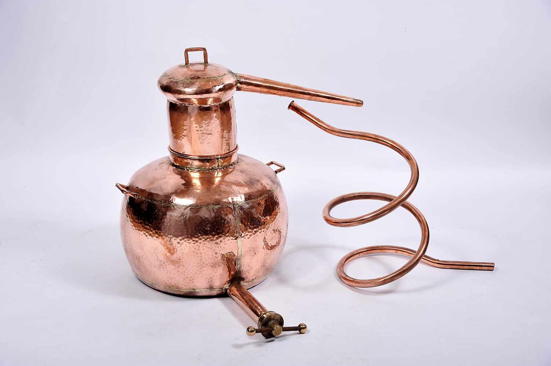 An Alembic with serpentine, hammered copper, Portuguese, 19th/20th C., small bruises, missing